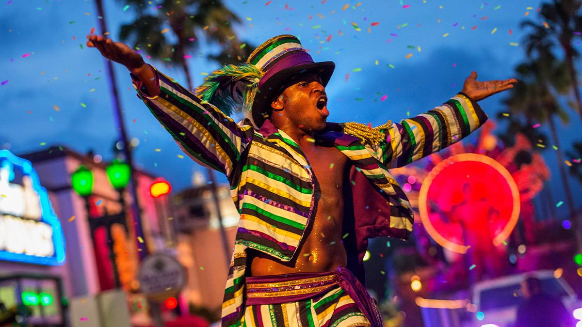 man wearing purple green and gold mardi gras costume at Universal's Spirit of New Orleans Mardi Gras Bash in Orlando, Florida, USA